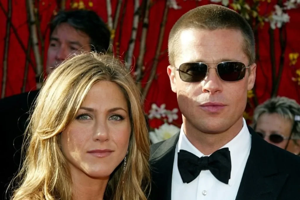 A realistic close-up red carpet portrait of Jennifer Aniston looking forward with green eyes alongside Brad Pitt wearing aviator sunglasses, a tuxedo, and a black bow tie against a vibrant red backdrop.