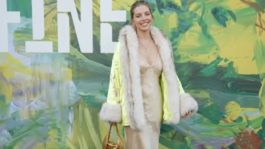 Actress Sienna Miller wearing a neon-embroidered silk robe coat with dramatic fur trim over a slip dress at the Serpentine Summer Party.