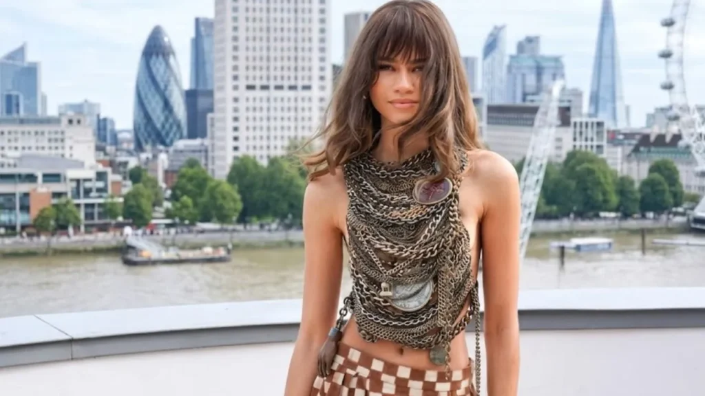 Actress Zendaya stepping out in a tailored, long-sleeve plaid skirt ensemble from the Coach collection at a high-profile movie press tour stop.