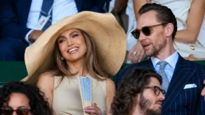 Jennifer Lopez wearing an oversized Ralph Lauren straw hat while seated next to Tom Hiddleston at the Wimbledon men's final.