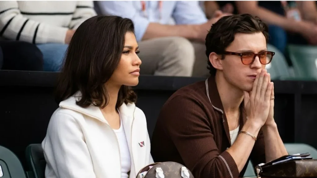 Tom Holland and Zendaya smiling together at a red carpet event.