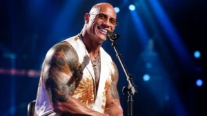 Dwayne Johnson smiling at a red carpet music premiere.