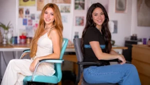 Shakira posing at a desk, recreating her famous 1997 newsroom photo.
