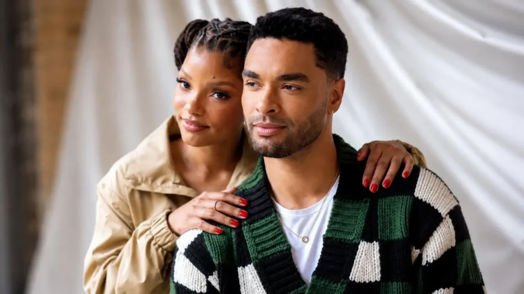 Halle Bailey and Regé-Jean Page standing together in a scenic Tuscan vineyard set.