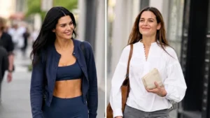 Katie Holmes walking down a city street wearing wide leg denim jeans and black high vamp glove flats