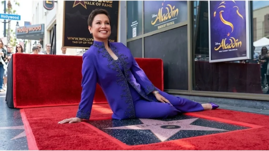 Lea Salonga posing proudly beside her new star on the Hollywood Walk of Fame.